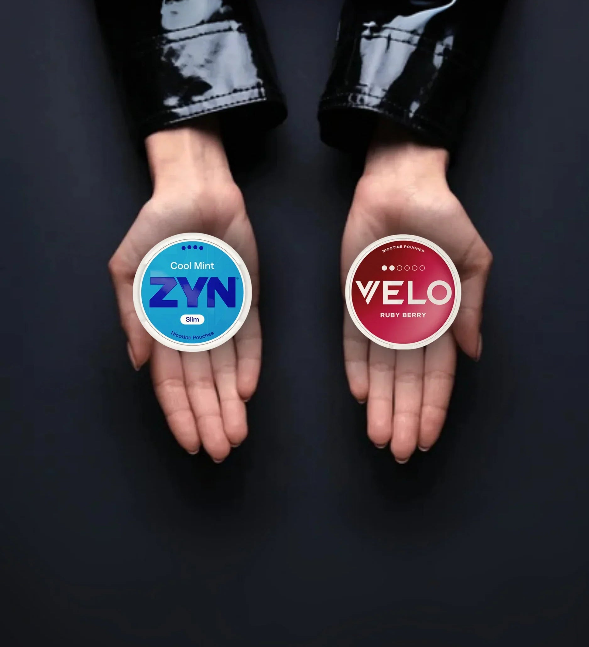 Two hands holding a one can of nicotine pouches in each hand